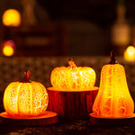 Short, medium and tall crackle pumpkin LED lights glowing in an autumn display