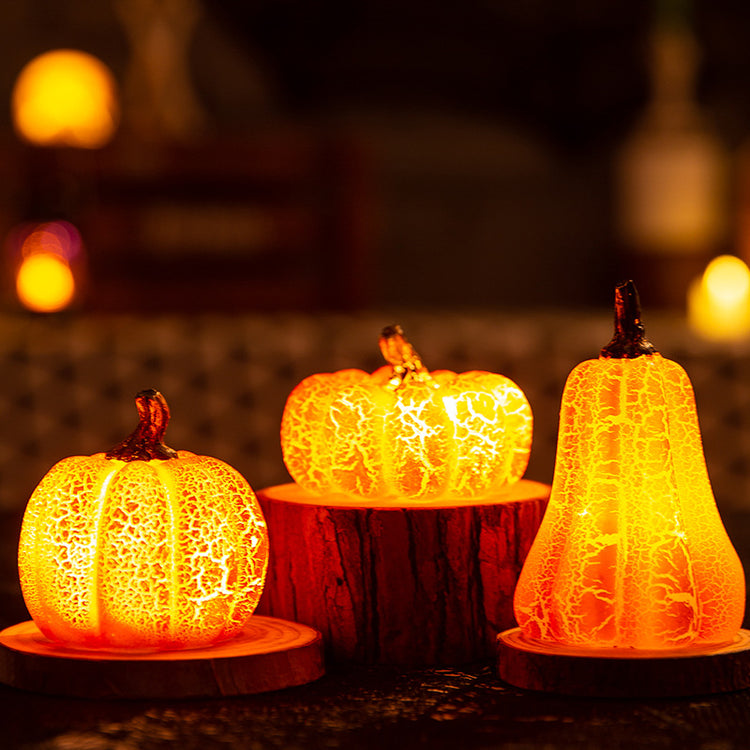 Short, medium and tall crackle pumpkin LED lights glowing in an autumn display