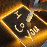 Close-up of a handwritten message glowing on the acrylic LED board