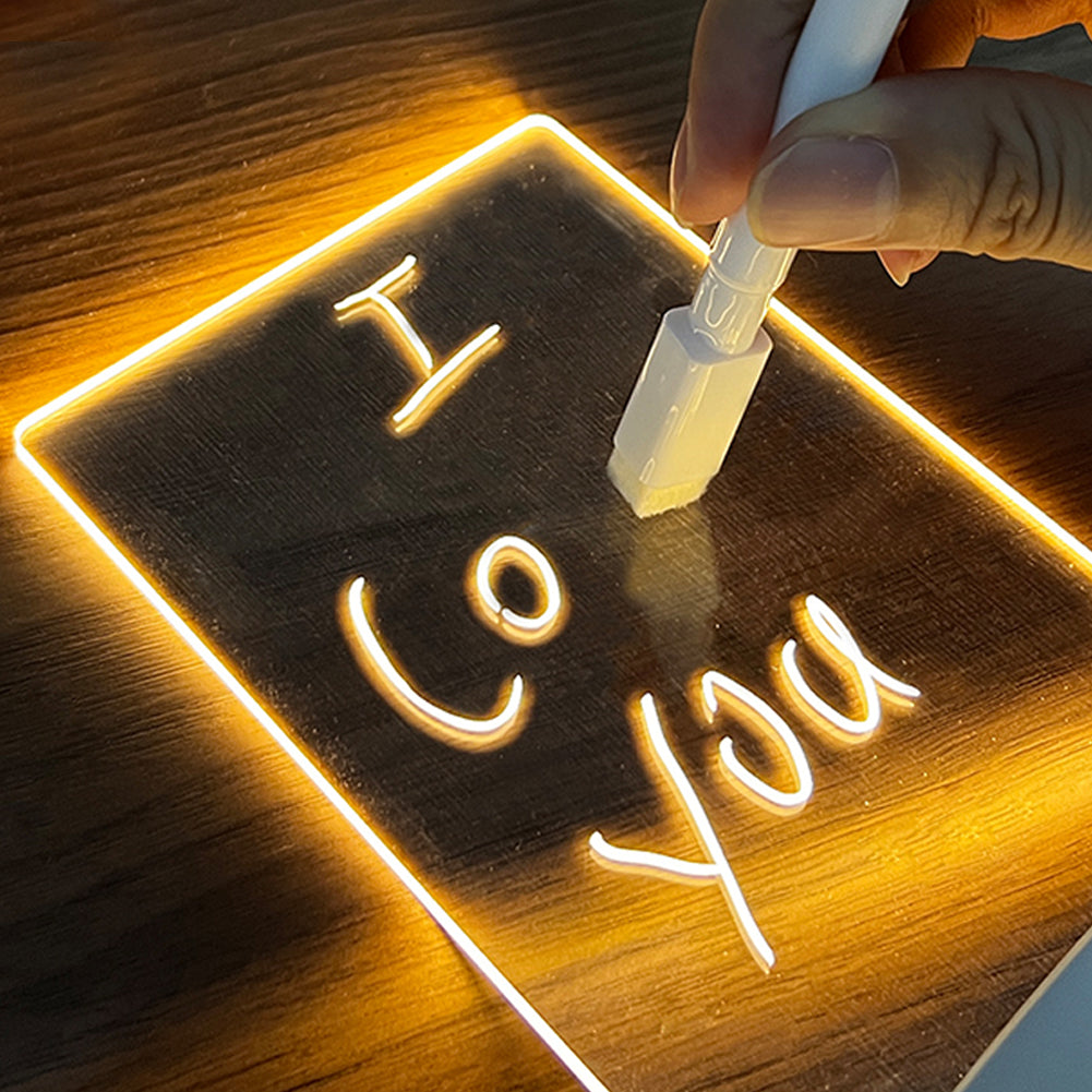 Close-up of a handwritten message glowing on the acrylic LED board